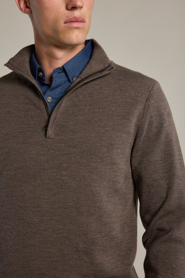 A man models the Barkers Brandon ZQRX Merino 1/4 Zip sweater in brown over a blue button-up, shown from shoulders to chest against a neutral background—an ideal layering piece.