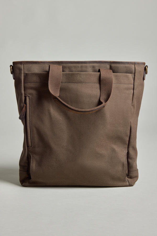 The Barkers Foxton Canvas Convertible Tote is a brown cotton bag with short handles, a side zipper pocket, and a minimalist design, shown against a plain light background.