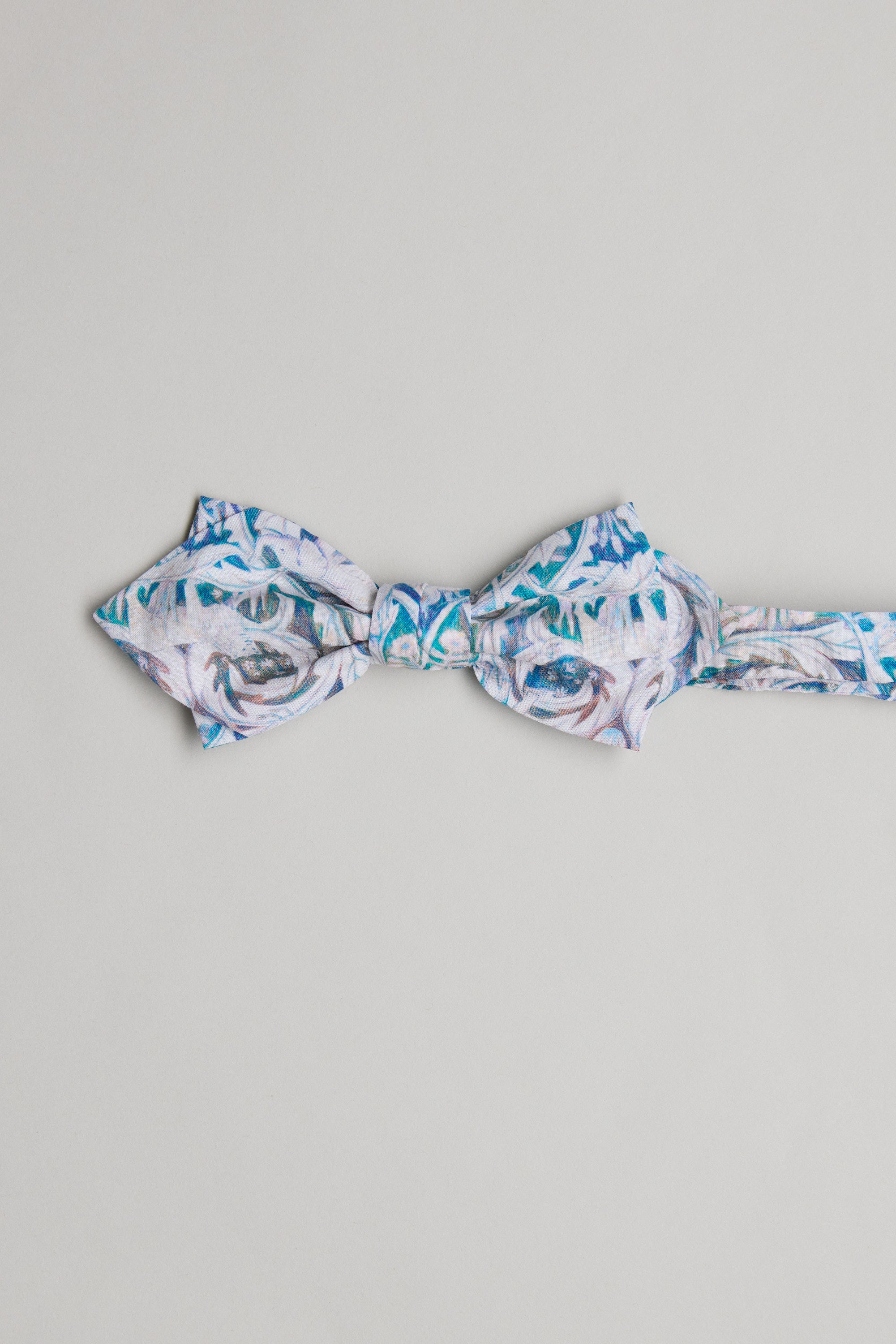 The Liberty Valerie Bow Tie by Liberty features blue, white, and grey swirls with floral patterns, handcrafted in New Zealand from soft Tana Lawn cotton and shown on a plain light grey background.