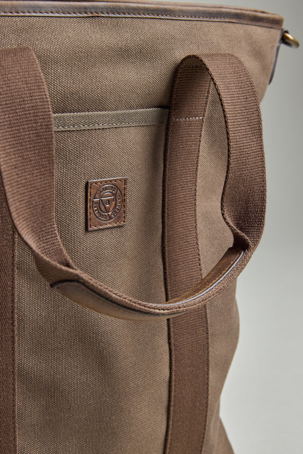 Close-up of the Foxton Canvas Convertible Tote by Barkers, showing its brown cotton canvas, sturdy handles, and leather patch with embossed logo. Detailed stitching and fabric texture highlight the quality craftsmanship.