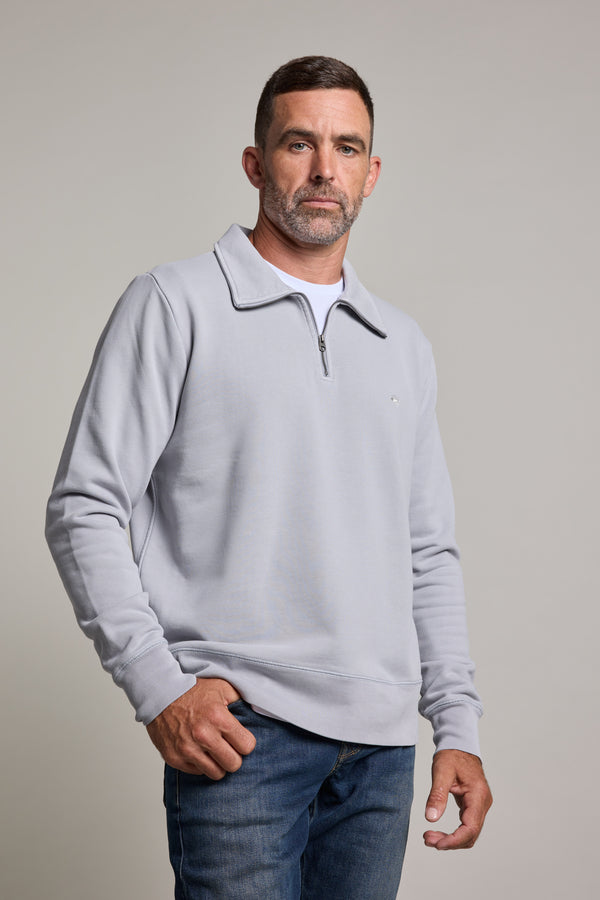 A man with short dark hair and a beard wears the Barkers Galway GD 1/4 Zip in light gray over a white shirt and blue jeans, standing against a plain light background and looking calmly at the camera.