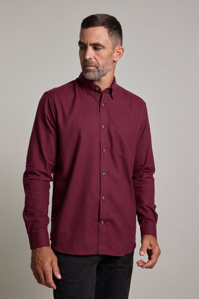 A man with short dark hair and a beard wears the Barkers Antonio Shirt—a classic fit, long-sleeved burgundy cotton-wool blend—paired with black pants. He looks slightly to the side with a neutral expression against a plain background.