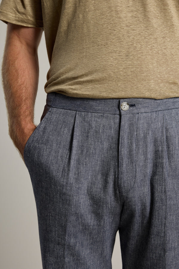Wearing Barkers Paden Twill Pant in grey and a beige t-shirt, one hand in pocket.