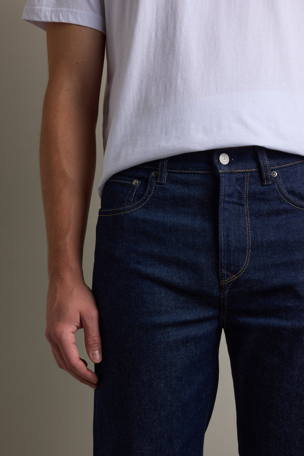 Person in a white t-shirt and Barkers Drifter Denim Relax Jean, shown shoulder to thigh.