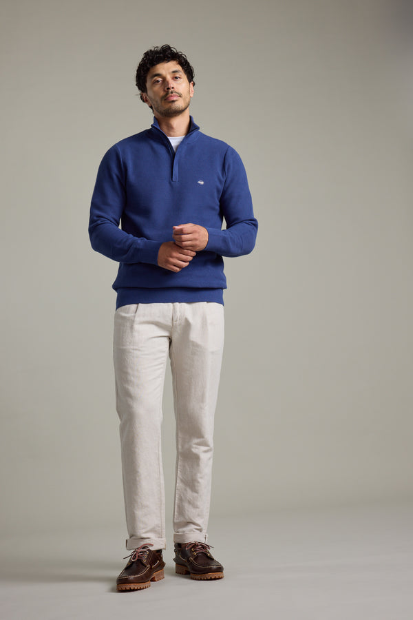 Man in Barkers Gaston Cotton 1/4 Zip Sweater, white pants, and brown shoes.