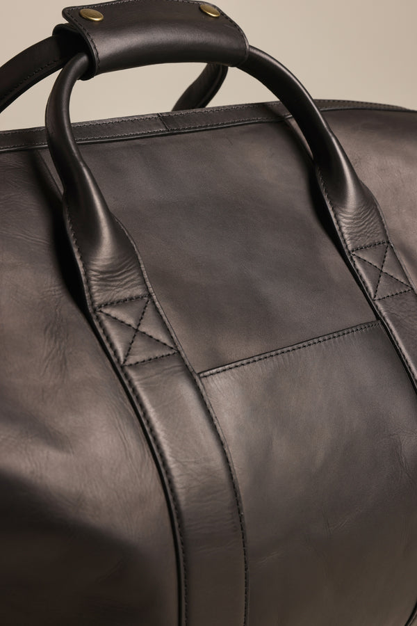 Close-up of the Barkers Costello Leather Weekender in black, featuring detailed stitching, two sturdy handles, and premium leather with a smooth matte finish, visible grain, and refined seam lines.