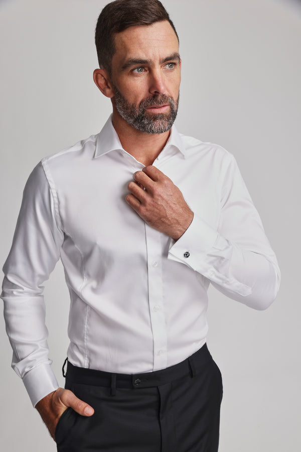 A man with short brown hair and a beard wears the Barkers Tribeca French Cuff Shirt and black trousers. He adjusts his collar, looking slightly to the side with a neutral expression against a plain background.