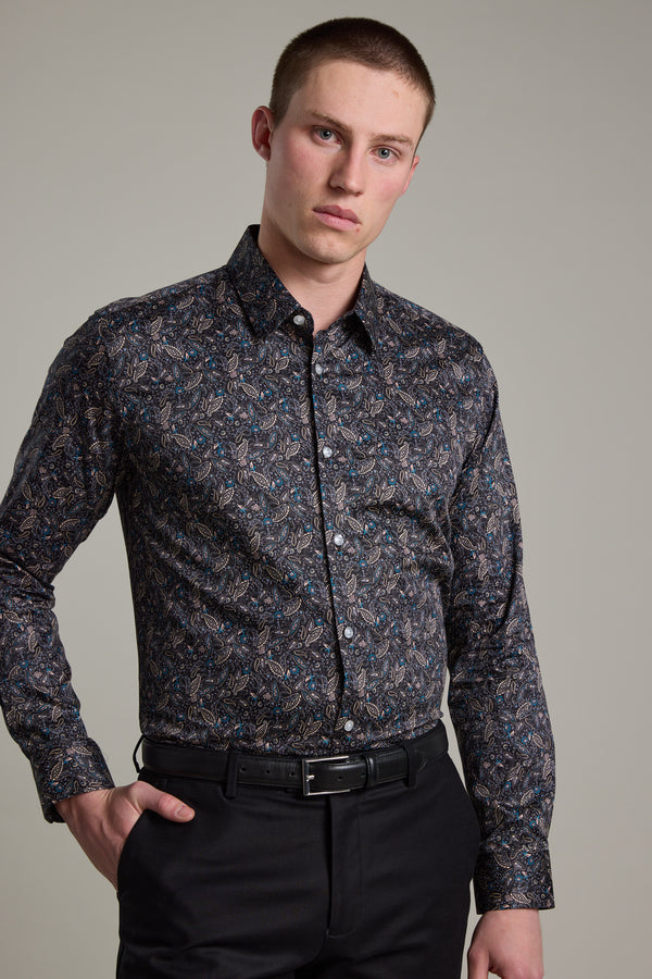 A young man with short hair wears the Barkers Hilton Print Shirt paired with black pants, standing against a plain light background, one hand on his hip.