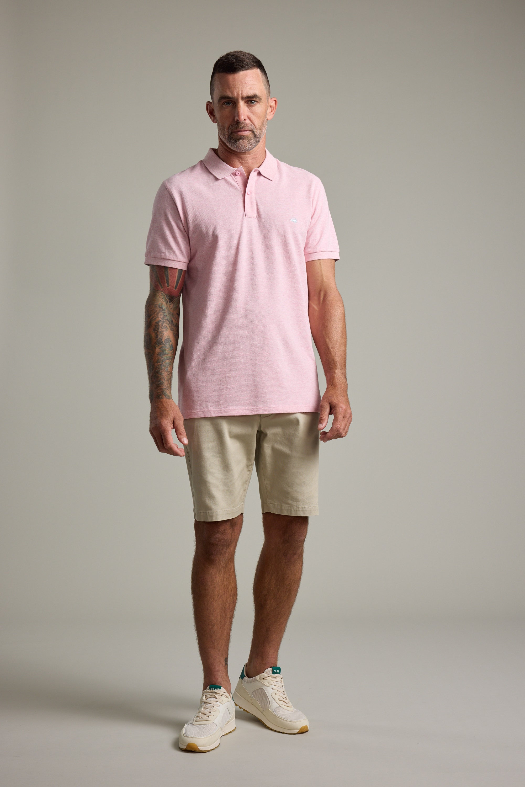 Man in Barkers Regent Pique Polo, beige shorts, and sneakers.