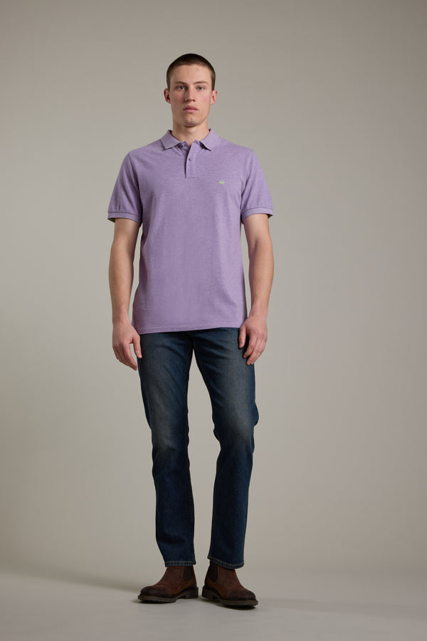 Man in a Barkers Regent Pique Polo, blue jeans, and brown shoes against a plain background.