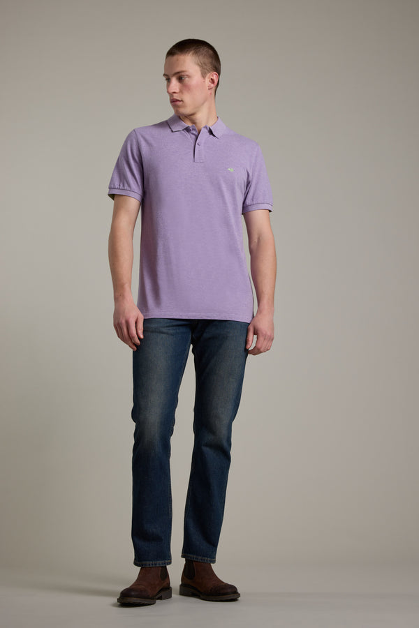 Man wears Barkers Regent Pique Polo with embroidered crayfish, blue jeans, and brown shoes.