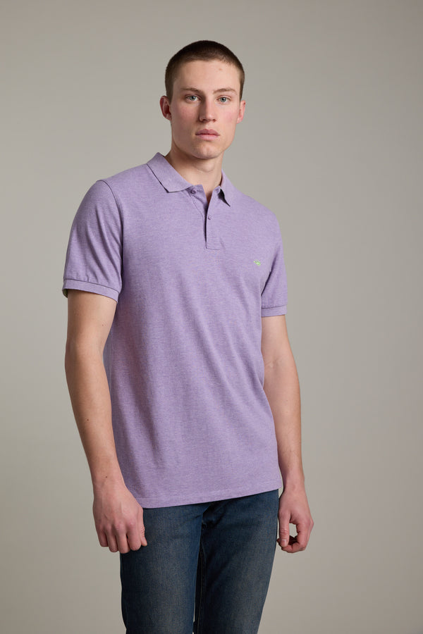 Young man in a Barkers Regent Pique Polo with embroidered crayfish on plain background.