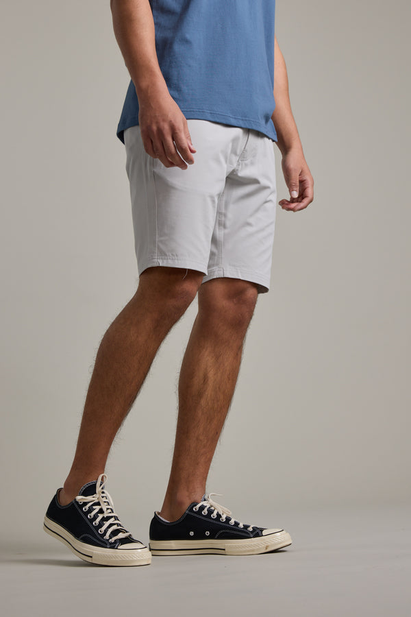 The lower half of a person is shown against a light gray background, wearing Barkers Hutchinson Walkshort in light gray and black low-top sneakers with white soles.