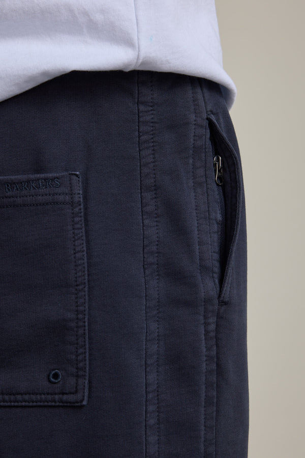 Close-up of a person in Barkers Organic Classic Print Track Pant and a white shirt.