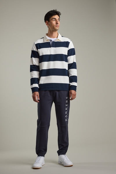 Man wears Barkers Provincial Long Sleeve Rugby Jersey with dark joggers and white sneakers.