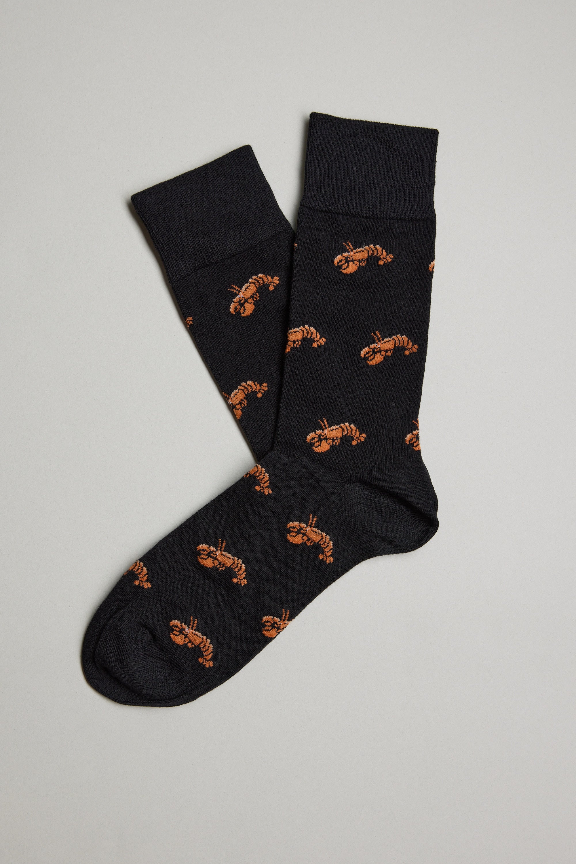 A pair of Barkers Ray Crayfish Socks, featuring an all-over print of small orange lobsters, are laid flat on a light gray background with one comfy sock slightly overlapping the other.
