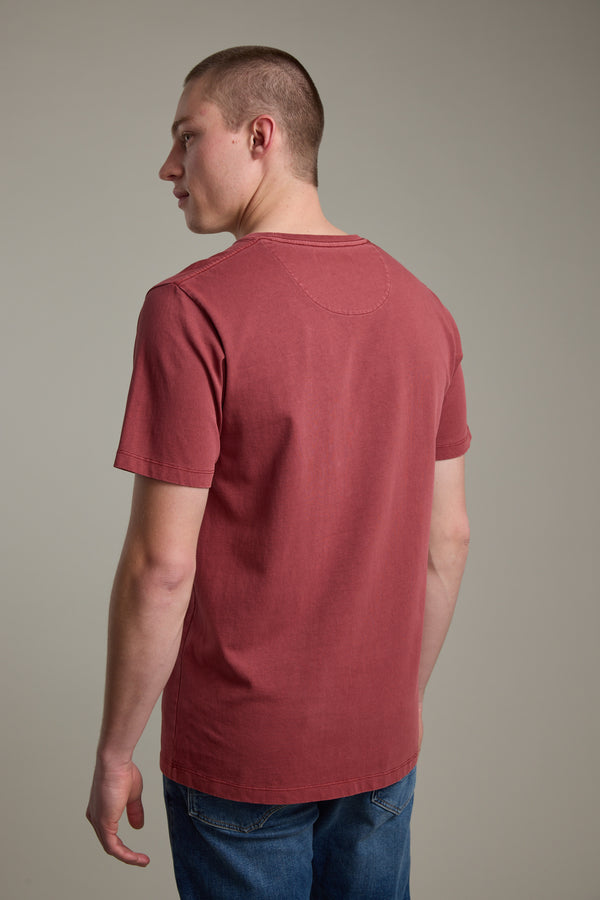 A young man with short hair wears the Barkers Newton Washed Tee and blue jeans, standing with his back to the camera and head turned slightly left against a plain, neutral background.