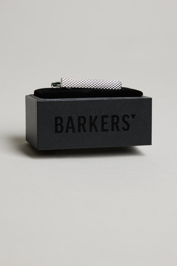 The Barkers Texture Tie Clip, featuring a textured silver-tone design, is displayed on a black box with the brand's logo, standing out against a light grey background.