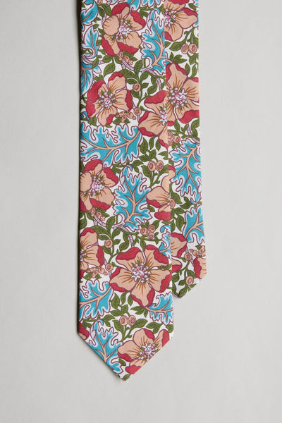 The Liberty Millie Francesca Tie by Liberty is handmade in New Zealand from Tana Lawn cotton and features a vibrant floral pattern in pink, orange, green, and blue on white, shown against a plain white background.