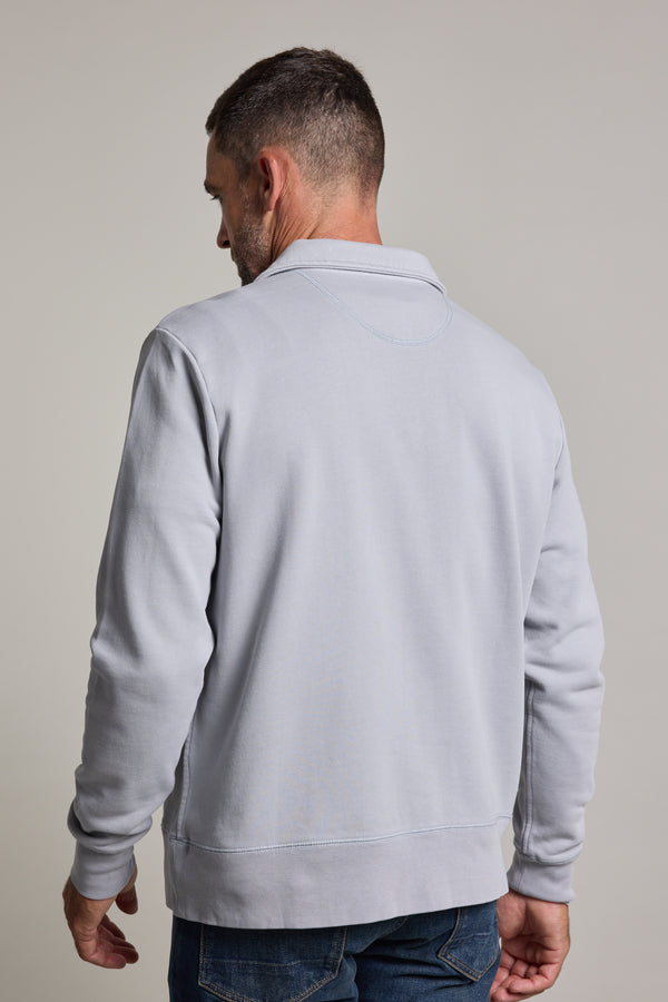 A man, seen from behind against a plain light background, wears a Barkers Galway GD 1/4 Zip in light gray with a stand collar, paired with dark jeans.