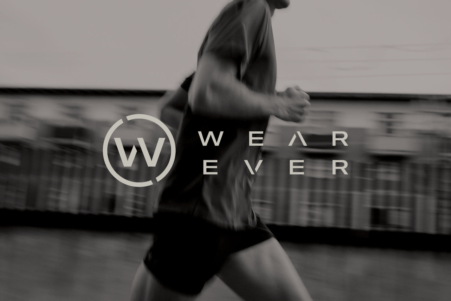 A person running outdoors in athletic wear, with the Wear Ever logo and text overlayed in the center of the image. The background is blurred, emphasizing motion.