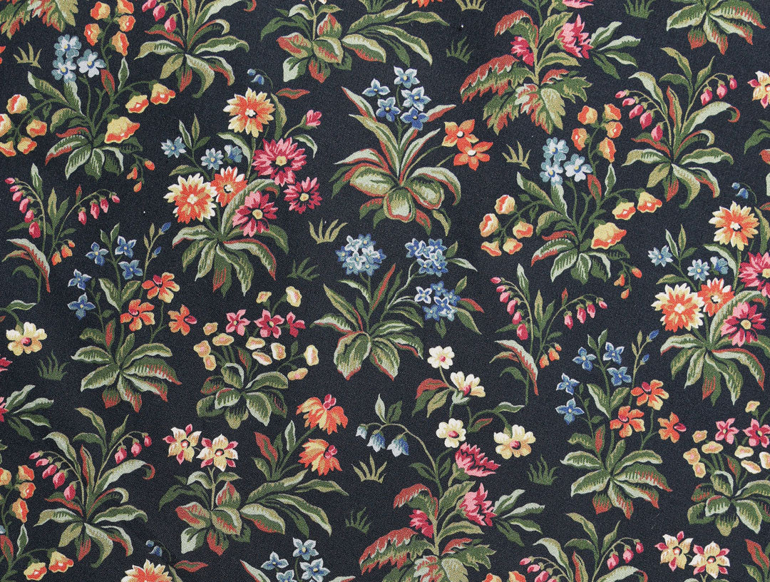 A colorful floral pattern featuring various types of flowers and green leaves on a dark background. The design is dense, with blossoms in red, yellow, blue, pink, and orange.