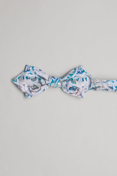 The Liberty Valerie Bow Tie by Liberty features blue, white, and grey swirls with floral patterns, handcrafted in New Zealand from soft Tana Lawn cotton and shown on a plain light grey background.