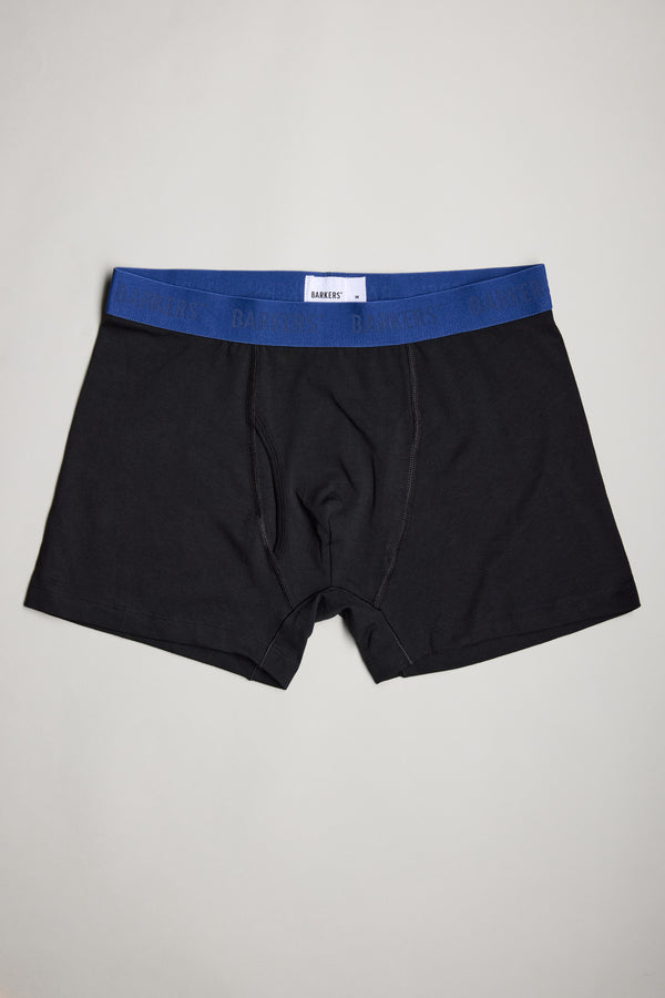 A set of Barkers 3-Pack Organic Trunk boxer briefs in black with a blue elastic waistband, featuring subtle branding, is displayed flat on a light gray surface—an ideal choice for your men’s underwear collection.