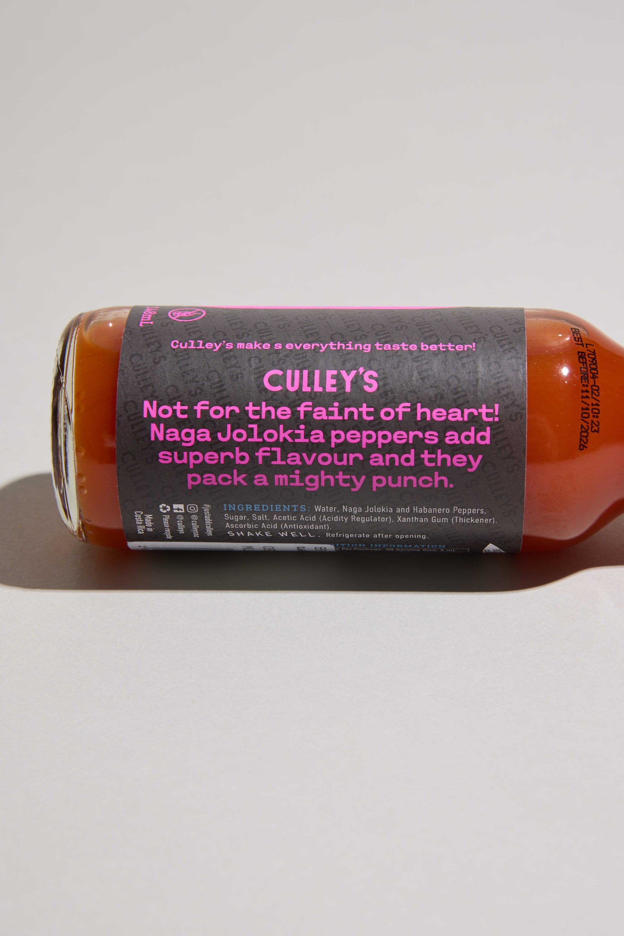 A bottle of Culley’s Malevolent Ghost Hot Sauce lies on its side. The label reads, “Not for the faint of heart! Naga Jolokia peppers add superb flavour and they pack a mighty punch,” with ingredient details below.