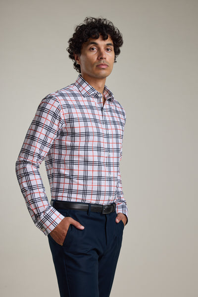 A man stands with hands in pockets, wearing the Barkers Wilma French Cuff Business Shirt—white, tailored fit with red, blue, and black plaid—and dark pants, set against a plain light background.