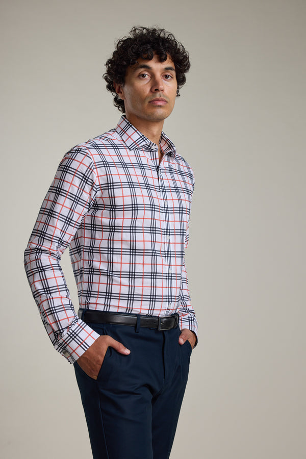 A man stands with hands in pockets, wearing the Barkers Wilma French Cuff Business Shirt—white, tailored fit with red, blue, and black plaid—and dark pants, set against a plain light background.