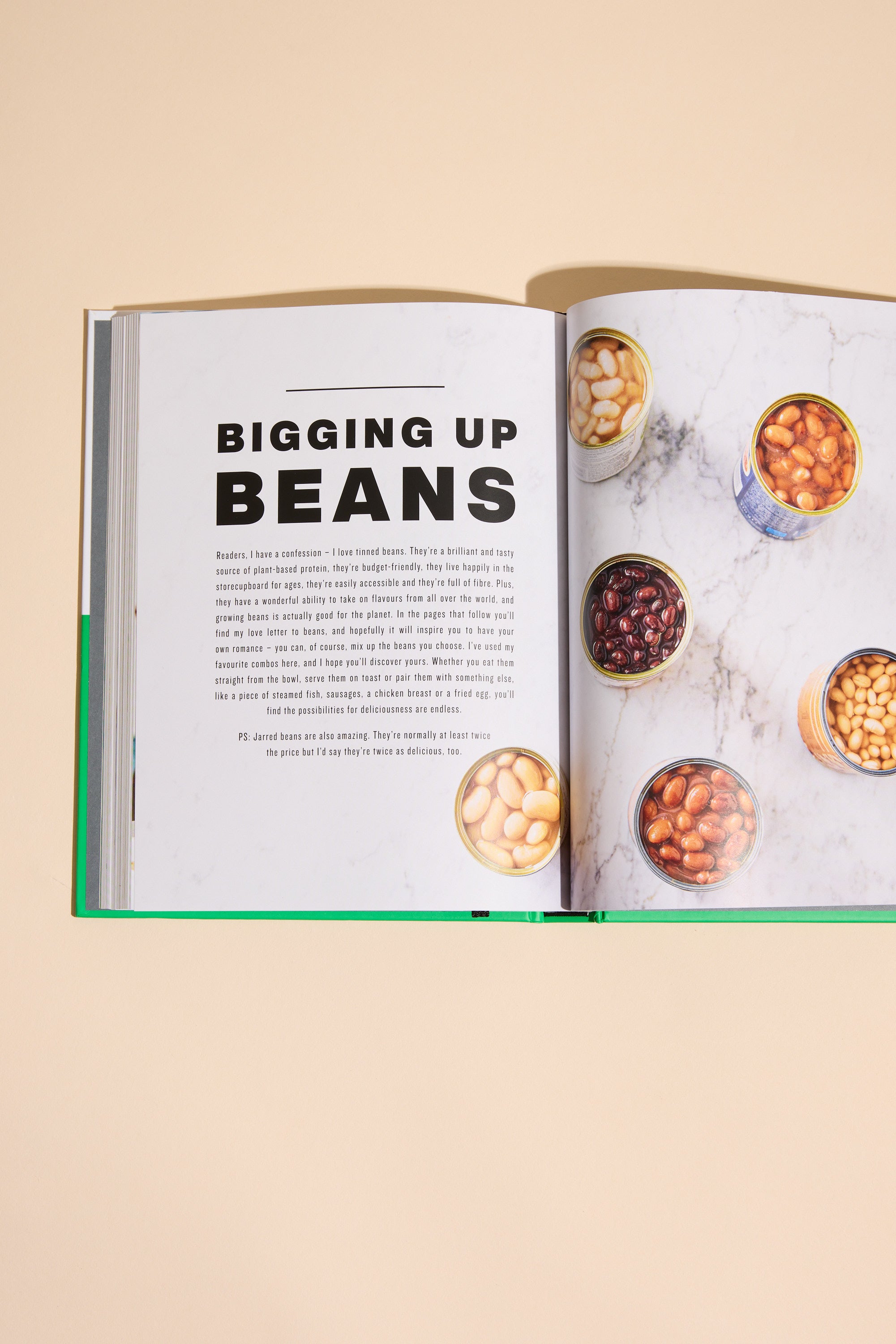 An open Simply Jamie cookbook by Other rests on a beige surface, featuring recipes and vibrant photos of white beans, black beans, and chickpeas in bowls and cans. Ideal for quick midweek meals.
