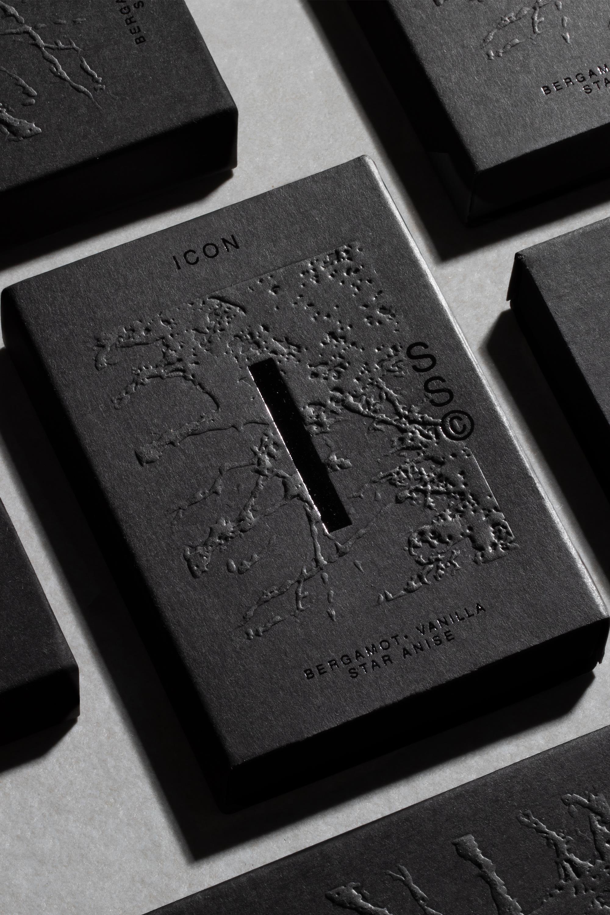 A black rectangular box labeled Solid State - Icon with embossed branch patterns and a central vertical slit. This solid cologne by Solid State features Australian scents: bergamot, vanilla, and star anise on a light background.