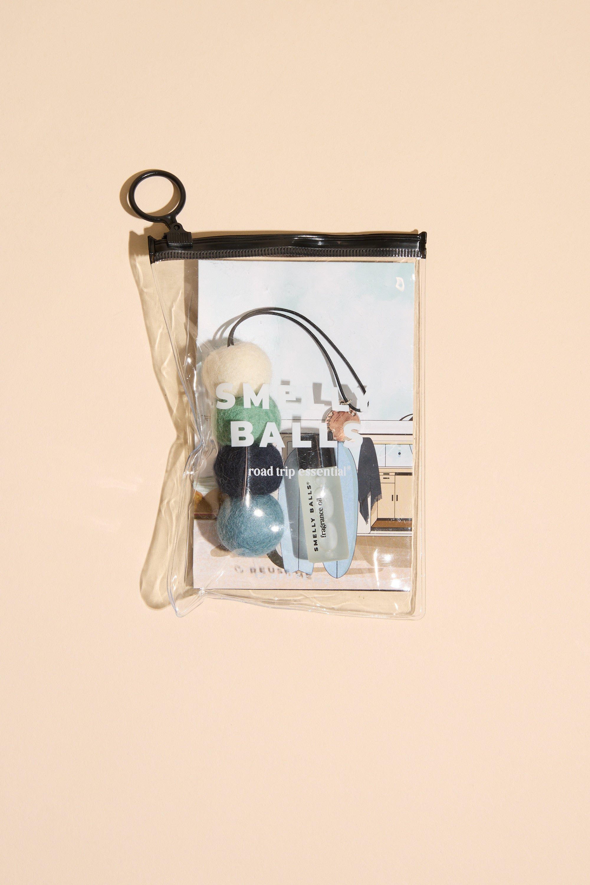 The Smelly Balls: Cove / Coastal Drift set by Other includes a small book, two fuzzy Smelly Balls, and a travel-size Coastal Drift scent in a clear zippered pouch—a reusable air freshener kit.