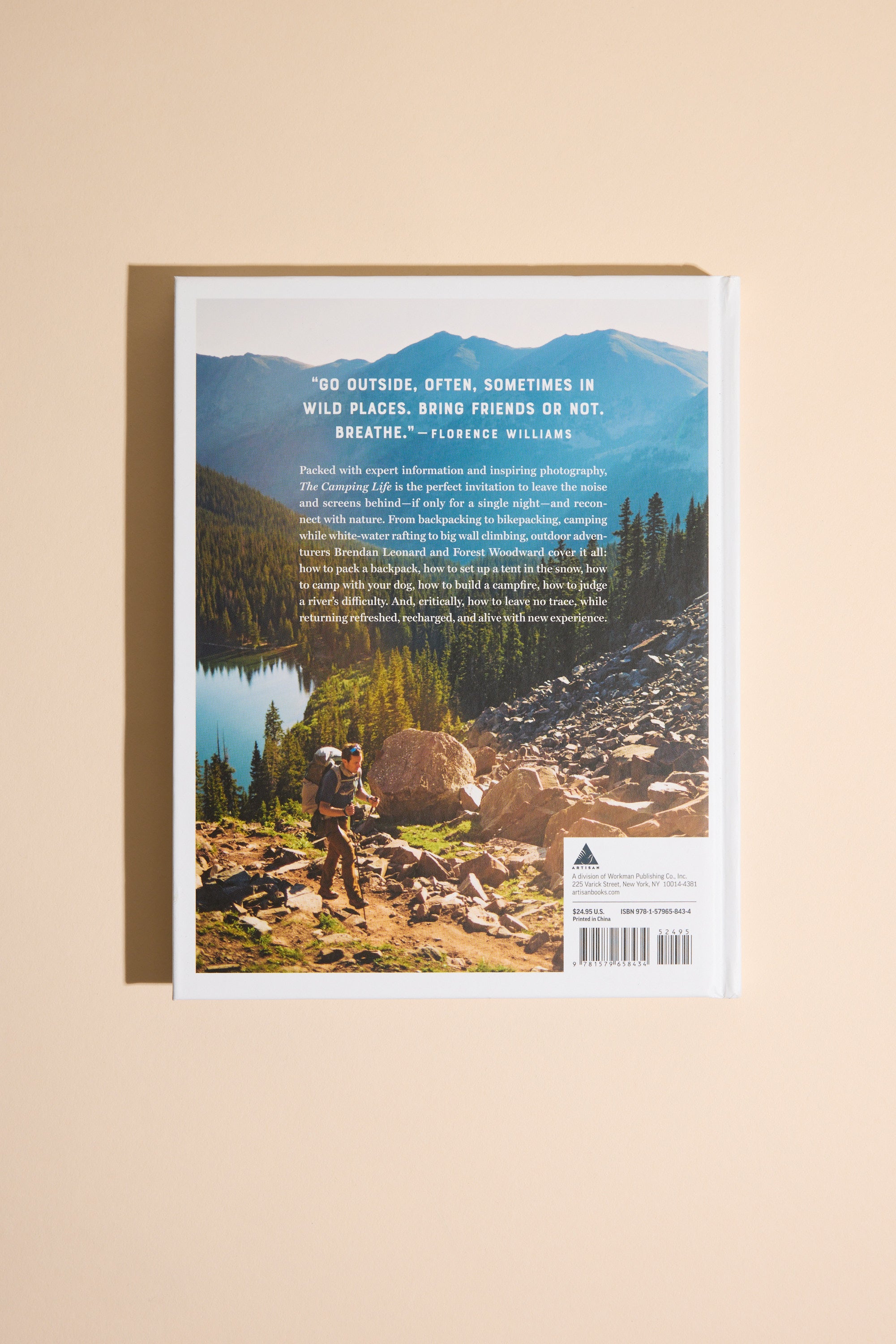 The back cover of Camping Life by Other shows a hiker with a backpack on rocky terrain near a lake, pine trees, and mountains under a blue sky—reflecting the spirit of New Zealand outdoor adventure. A quote and summary about exploration appear at the top.