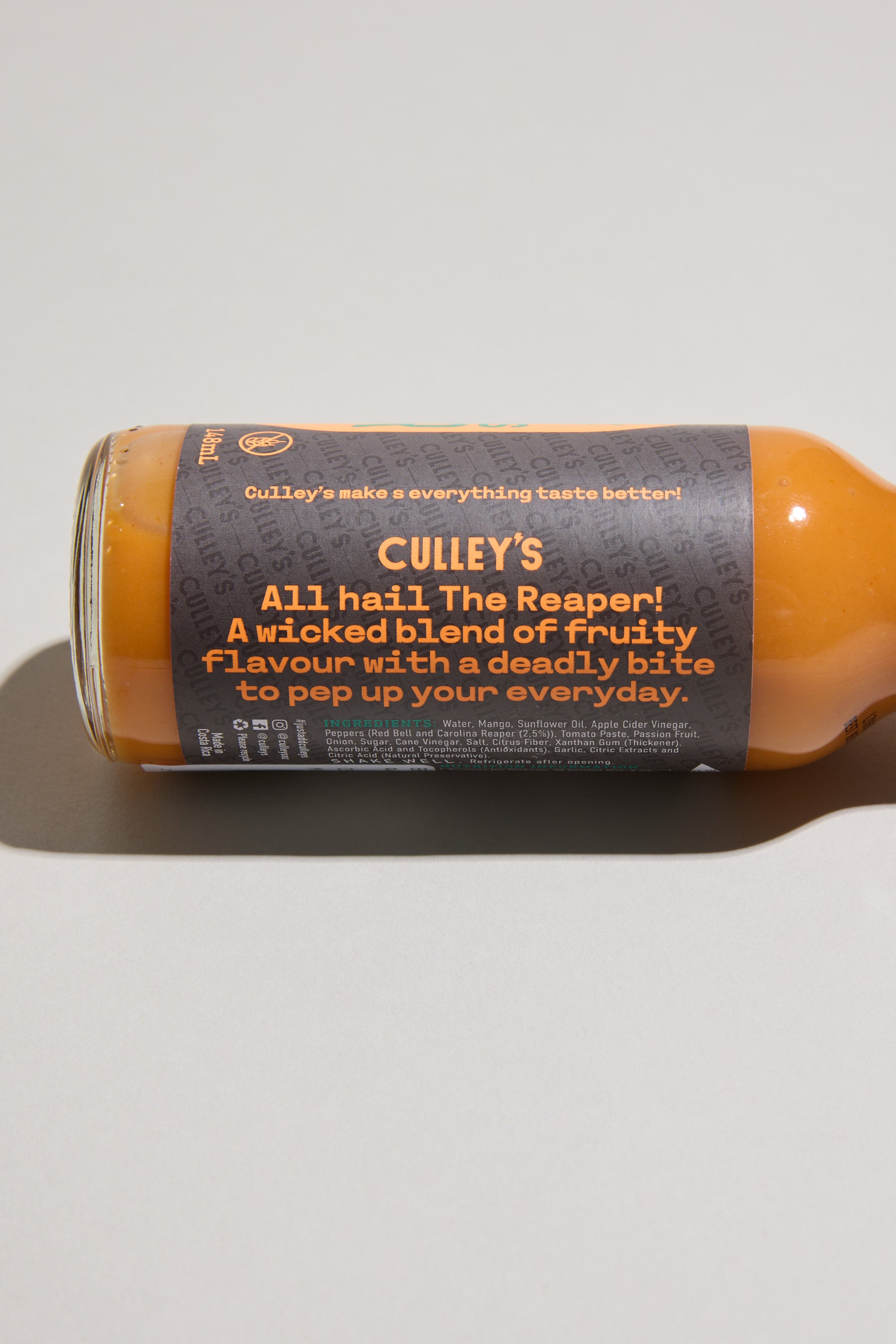 A bottle of Culley’s Furious Reaper Hot Sauce rests on its side, labeled "All hail The Reaper!" This fierce Culley’s blend features Carolina Reaper chili for a fruity flavor with intense heat, set against a plain light background.