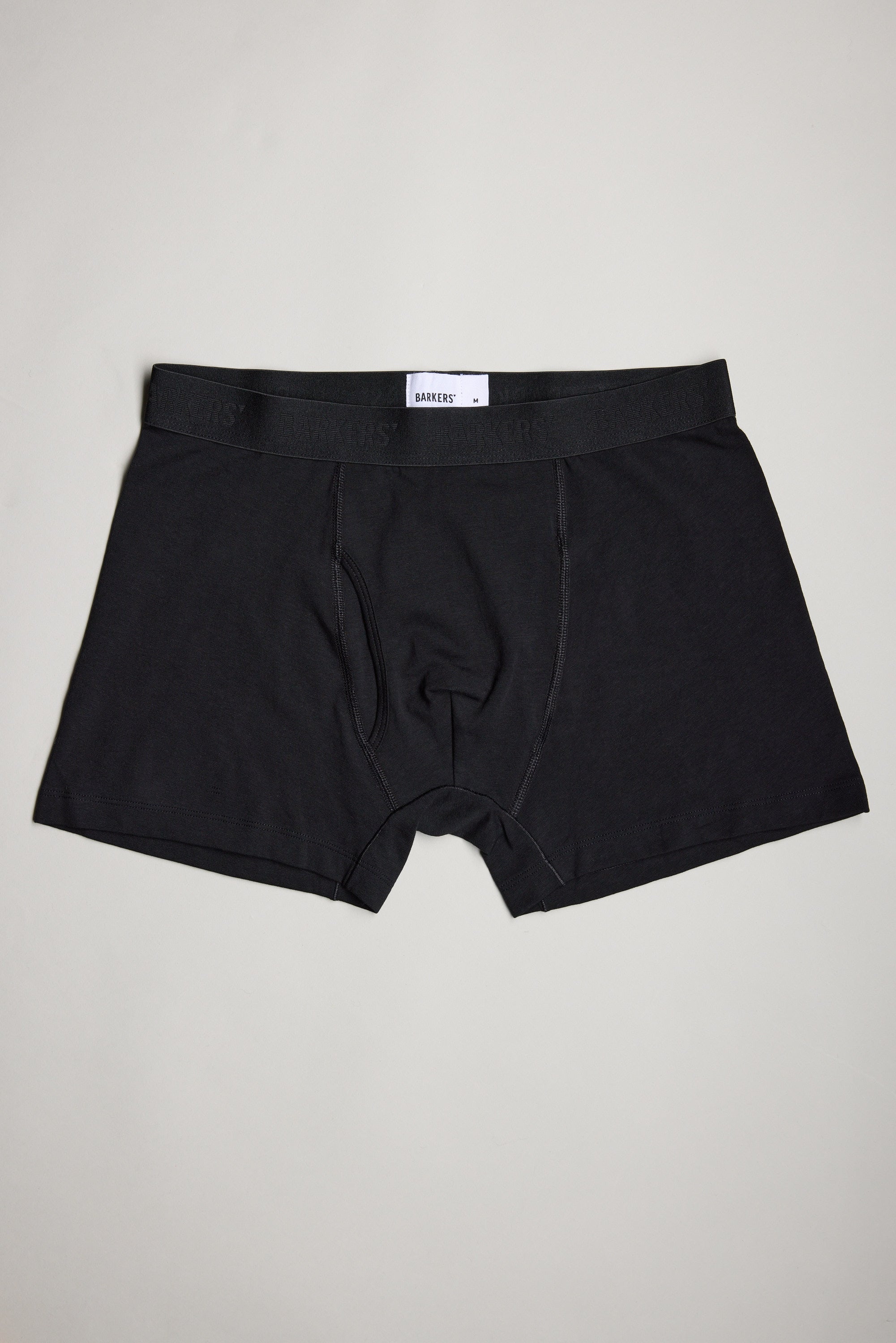 A trio of Barkers 3-Pack Organic Trunks in plain black rests on a light gray surface, showcasing breathable comfort and modern style in men's underwear.