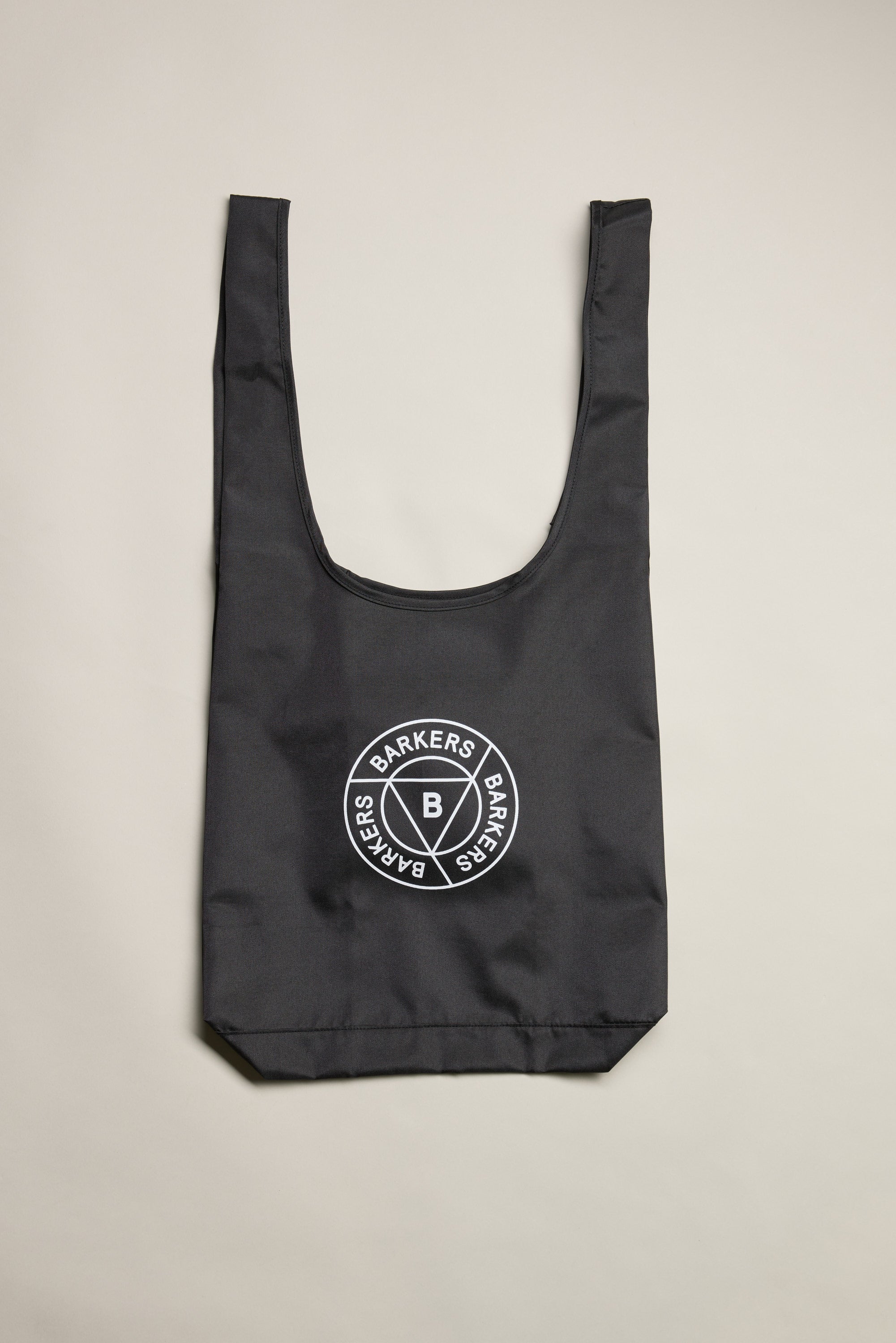 The Barkers Shopping Bag is a black recycled polyester tote with wide handles and a white circular Barkers logo in the center, shown flat on a light background.