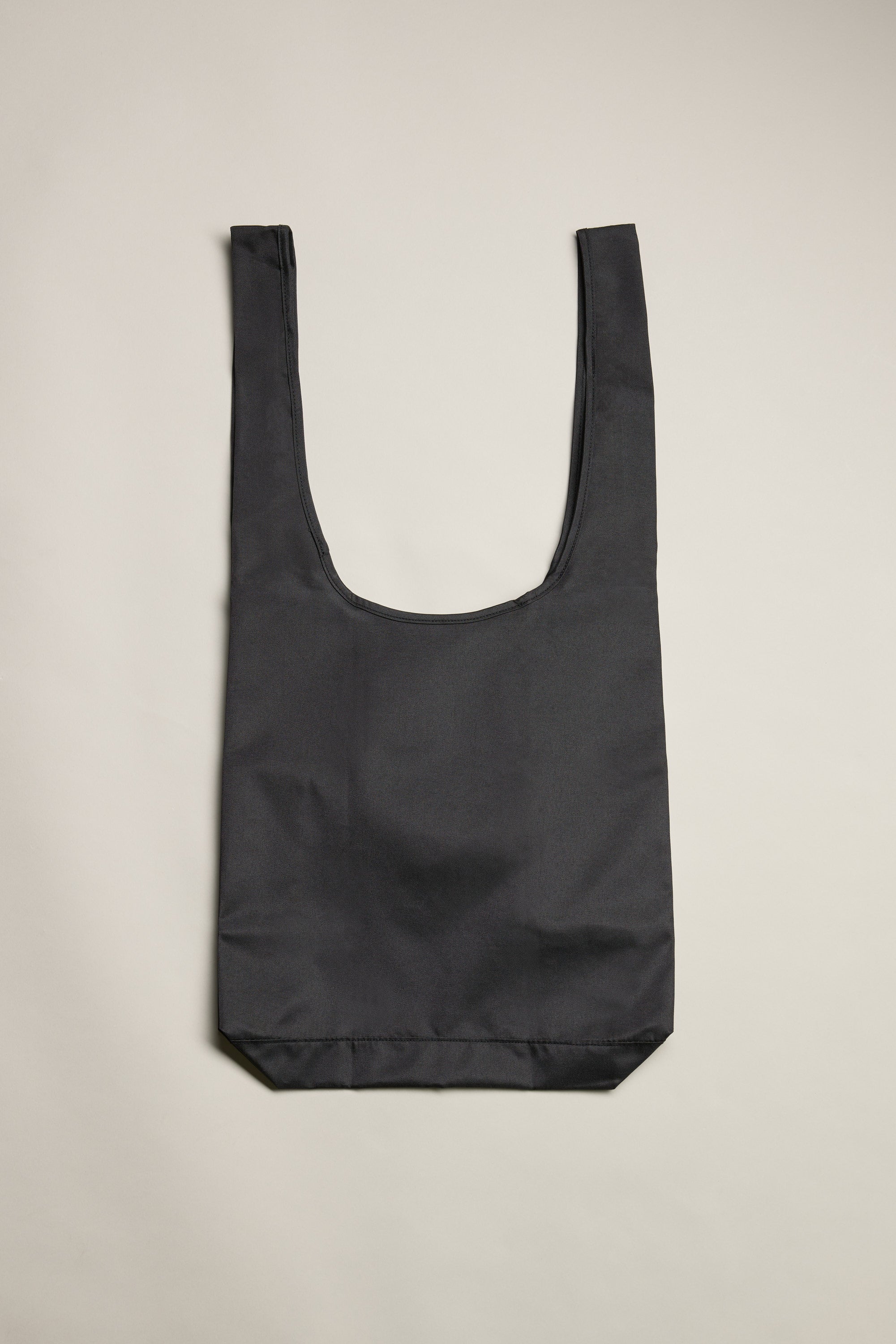 The Barkers Shopping Bag by Barkers is a durable, black recycled polyester tote with two wide handles—laid flat on a light beige background, it's perfect for everyday use.