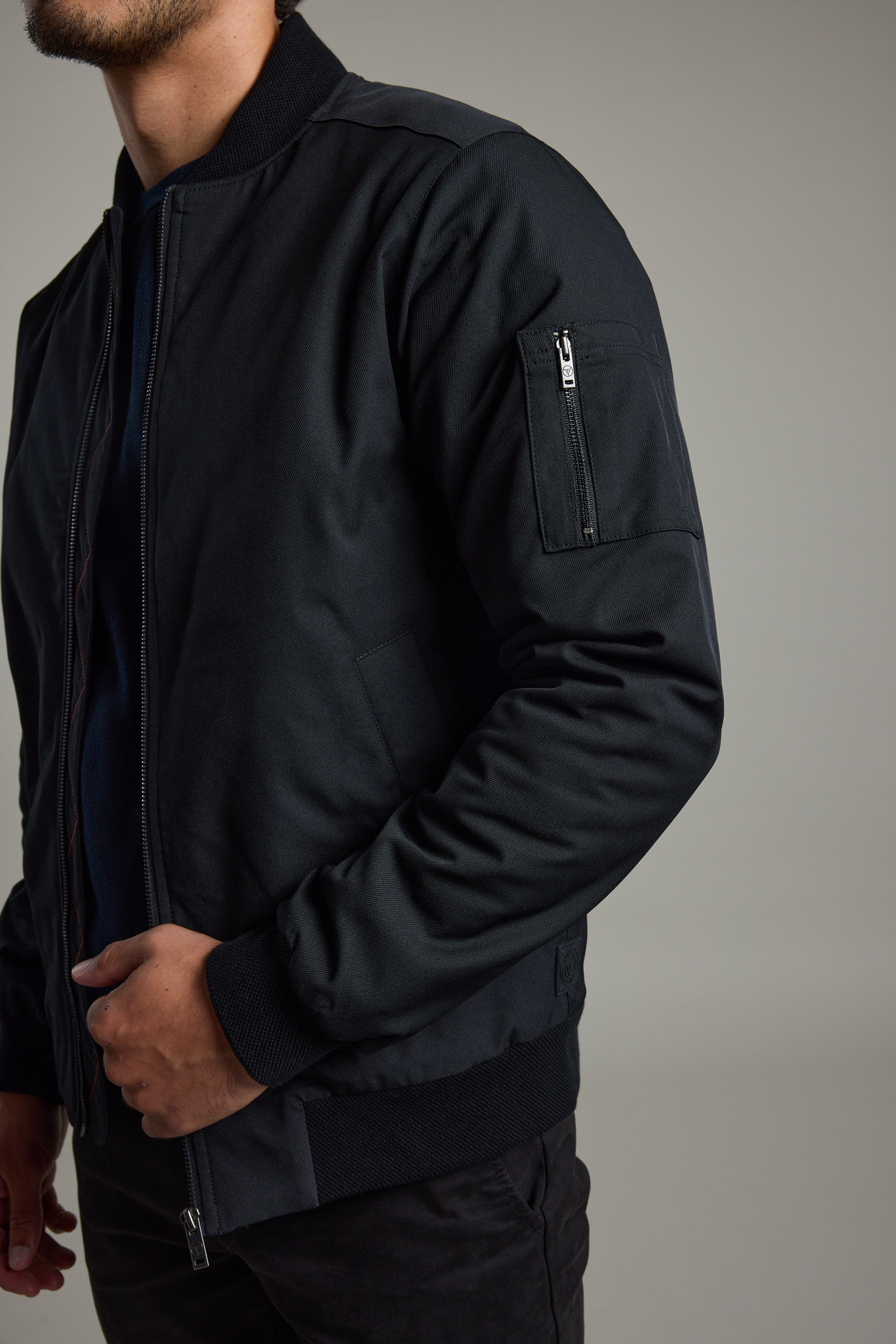 Man in Barkers Dunhill Bomber Jacket, hand in pocket, against a plain background.