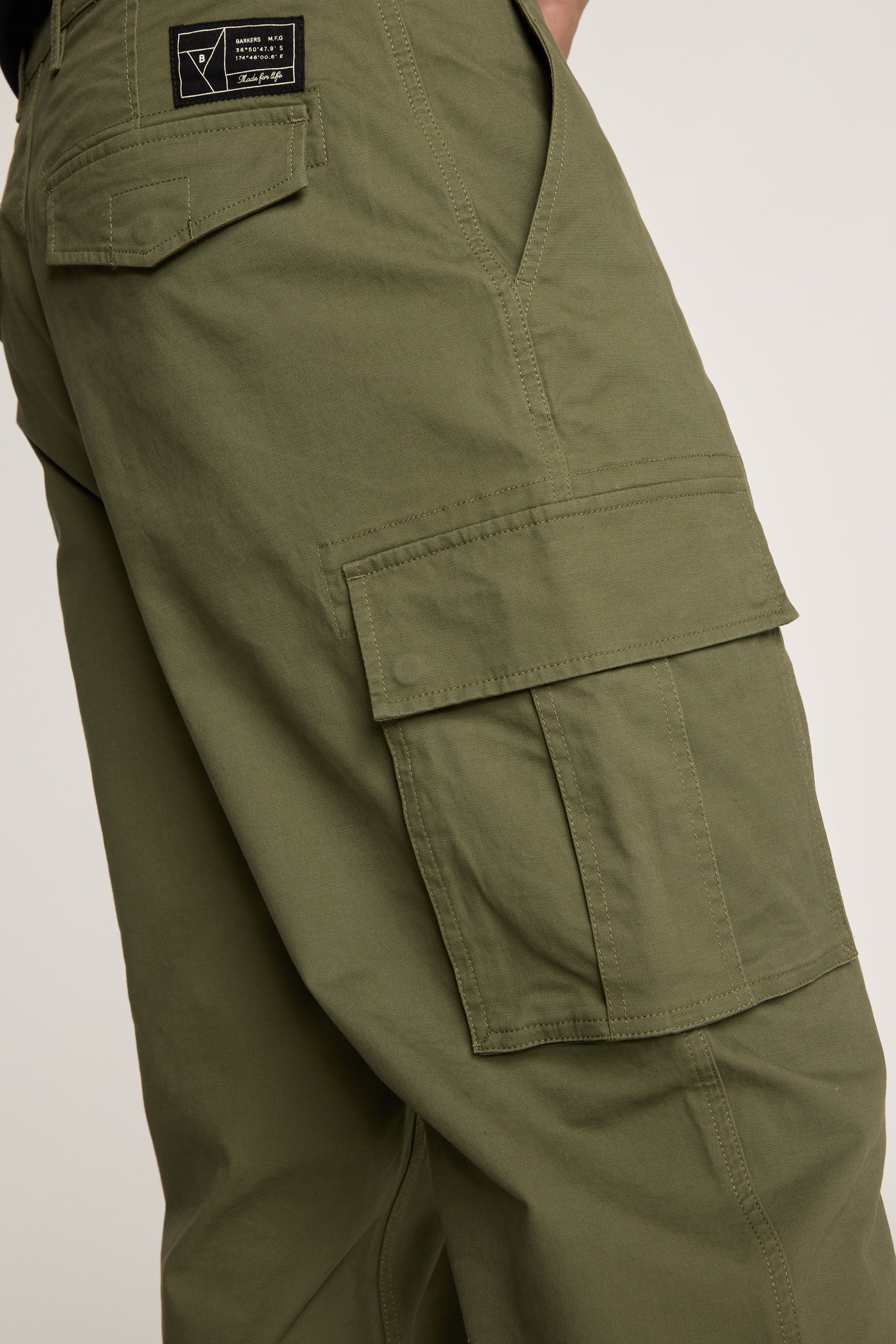 A close-up of the Barkers Barnard Cargo Pant, showcasing its relaxed fit twill cotton design, large side pockets, and a black patch above the back pocket with emphasis on detailed stitching.