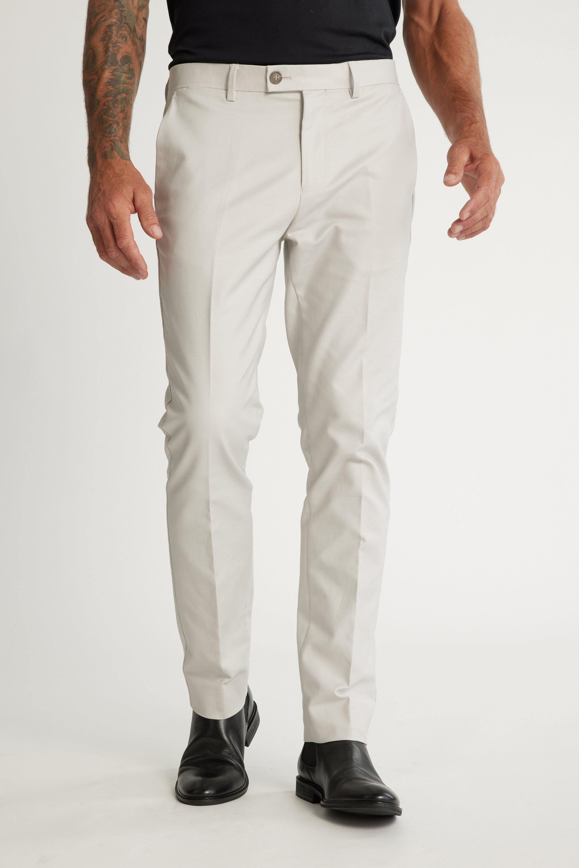 A man wears Barkers Lyndon Cotton Pants in a smart casual, slim-fit style with a black belt and black shoes, shown from the waist down against a plain white background.