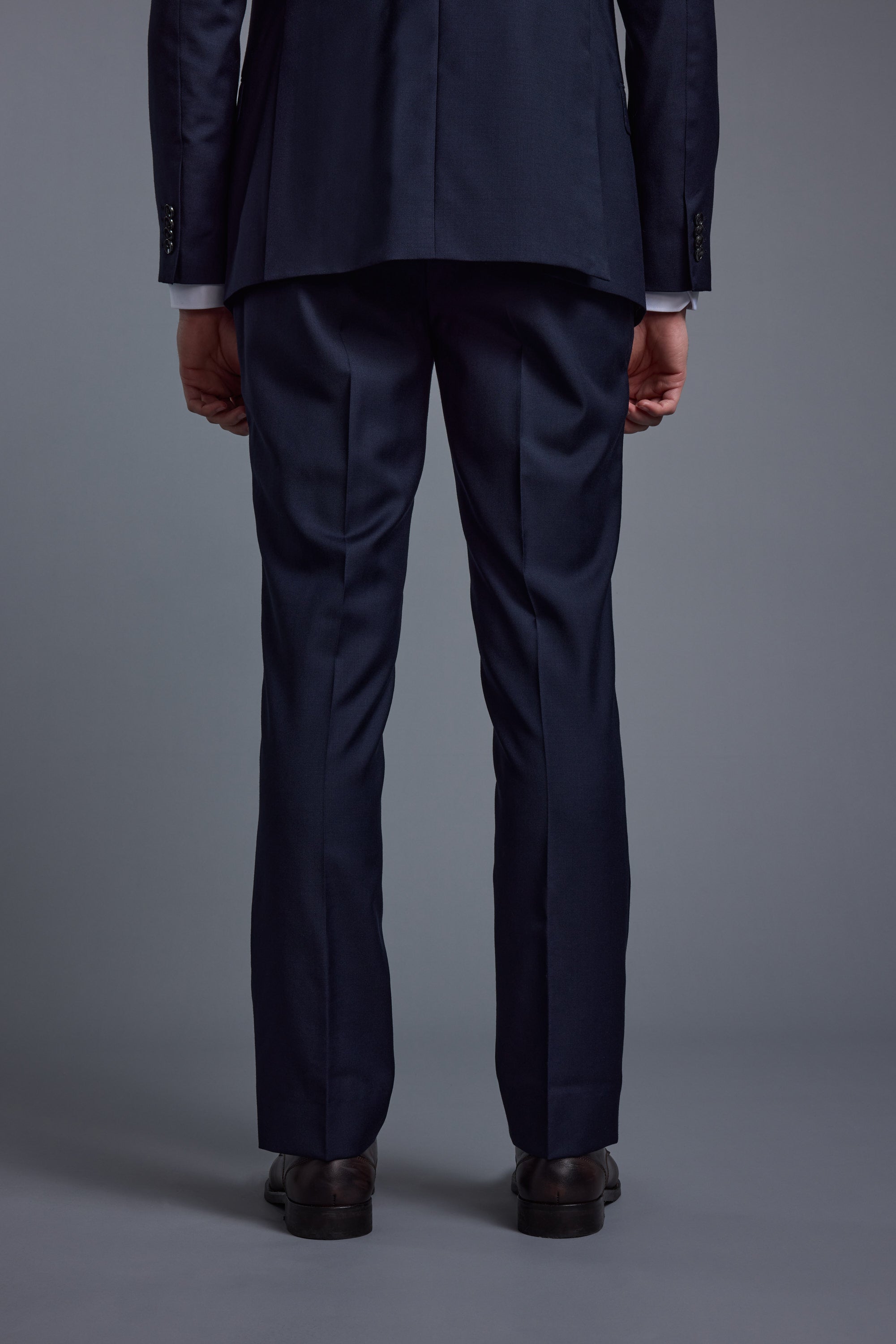 Person in Barkers Mayfair ZQrx Suit Trouser and dress shoes stands with back to camera.