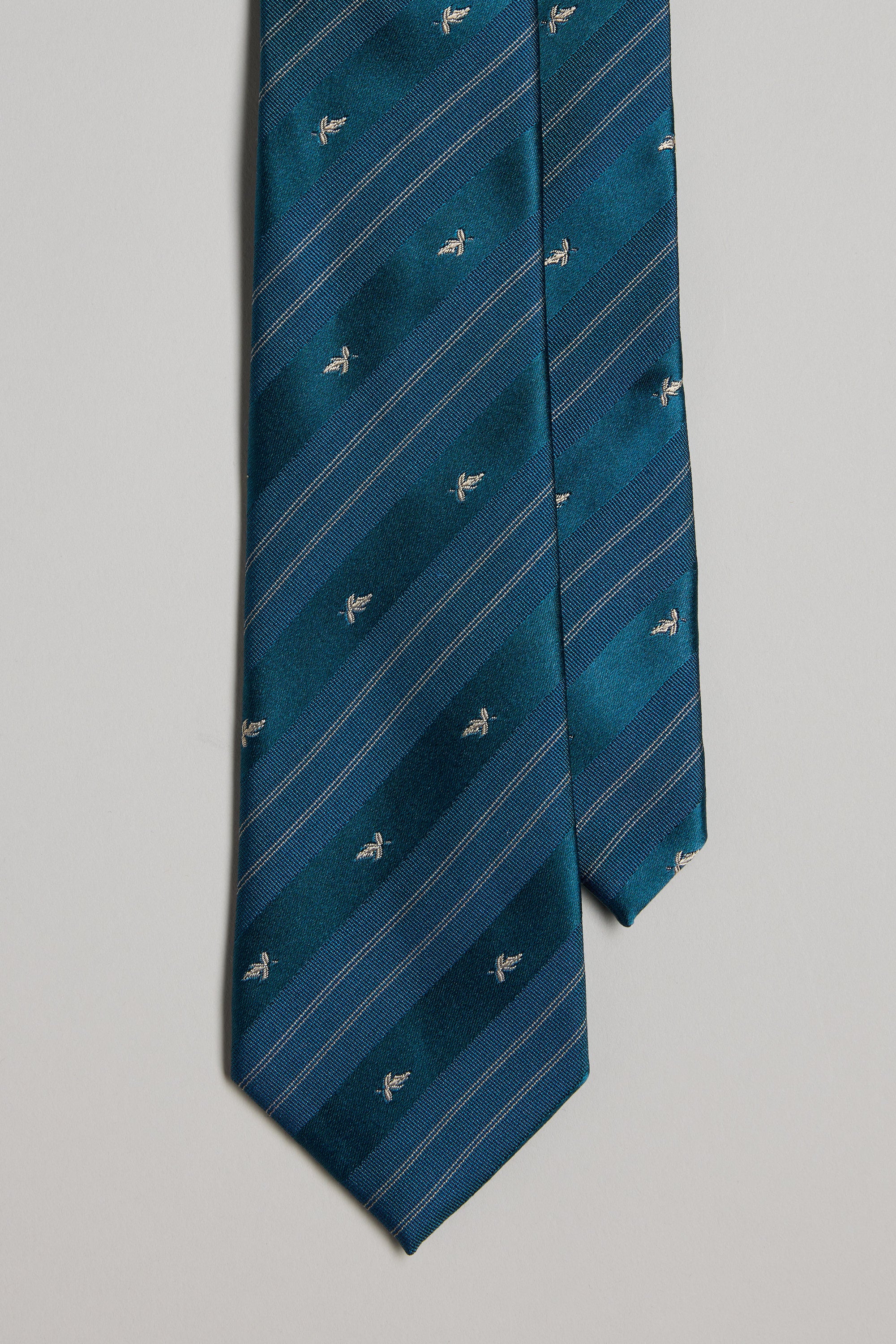 The Barkers Walker Stripe Tie features teal fabric with diagonal light blue stripes and small embroidered white alligators, ideal for pairing with silk pocket squares, shown against a plain light background.