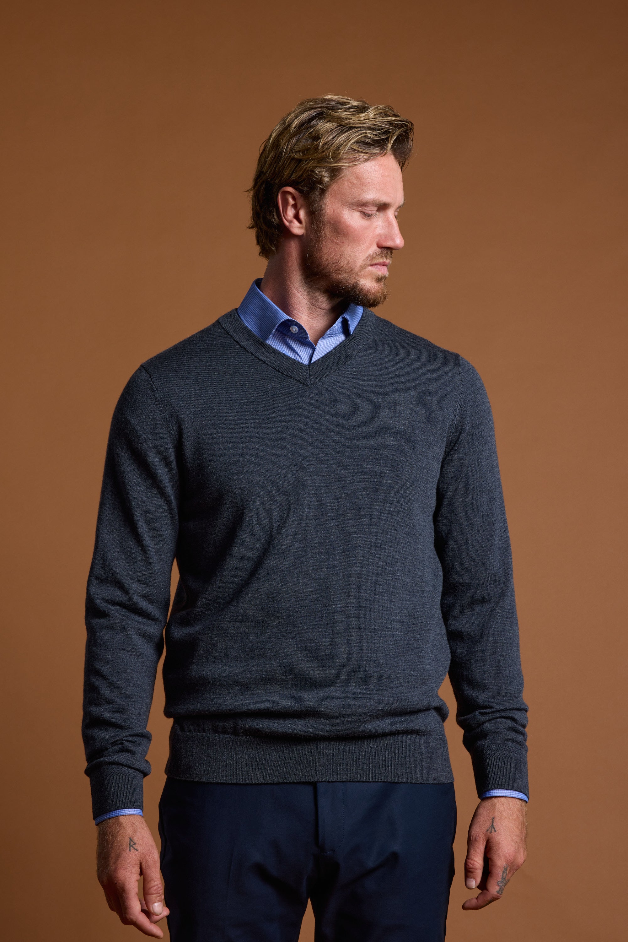 Man wears Barkers Skyland ZQrx Merino Vee, standing against a plain brown background.