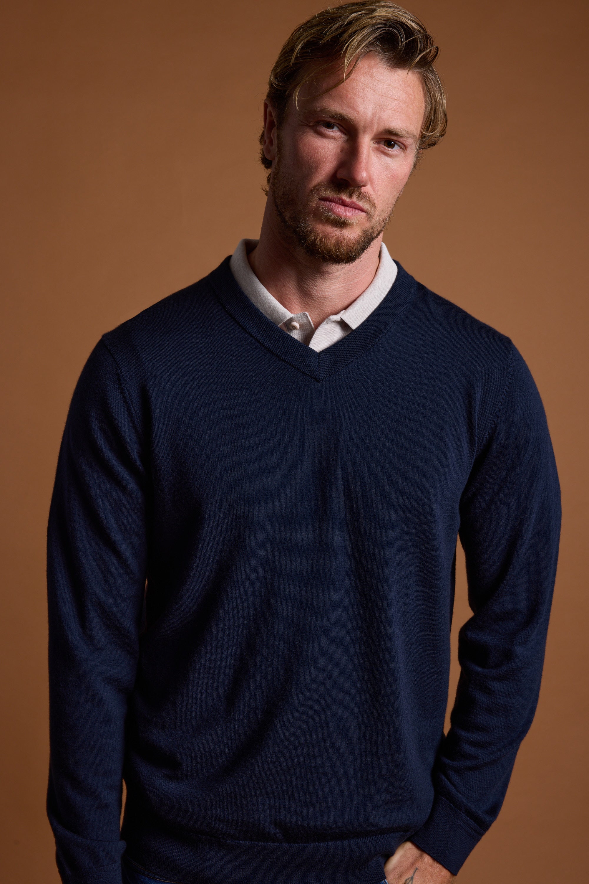 Man with short blond hair wears Barkers Skyland ZQrx Merino Vee against a brown background.