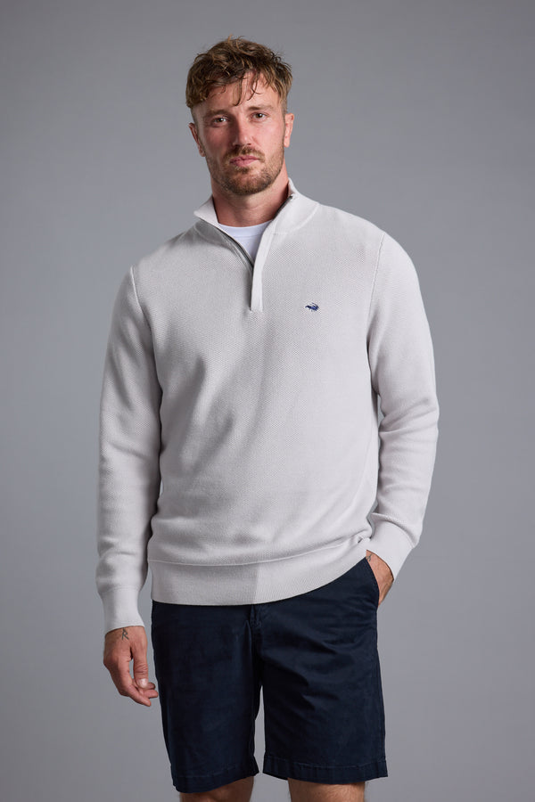 Man in Barkers Gaston Cotton 1/4 Zip Sweater and dark shorts, on a gray background.