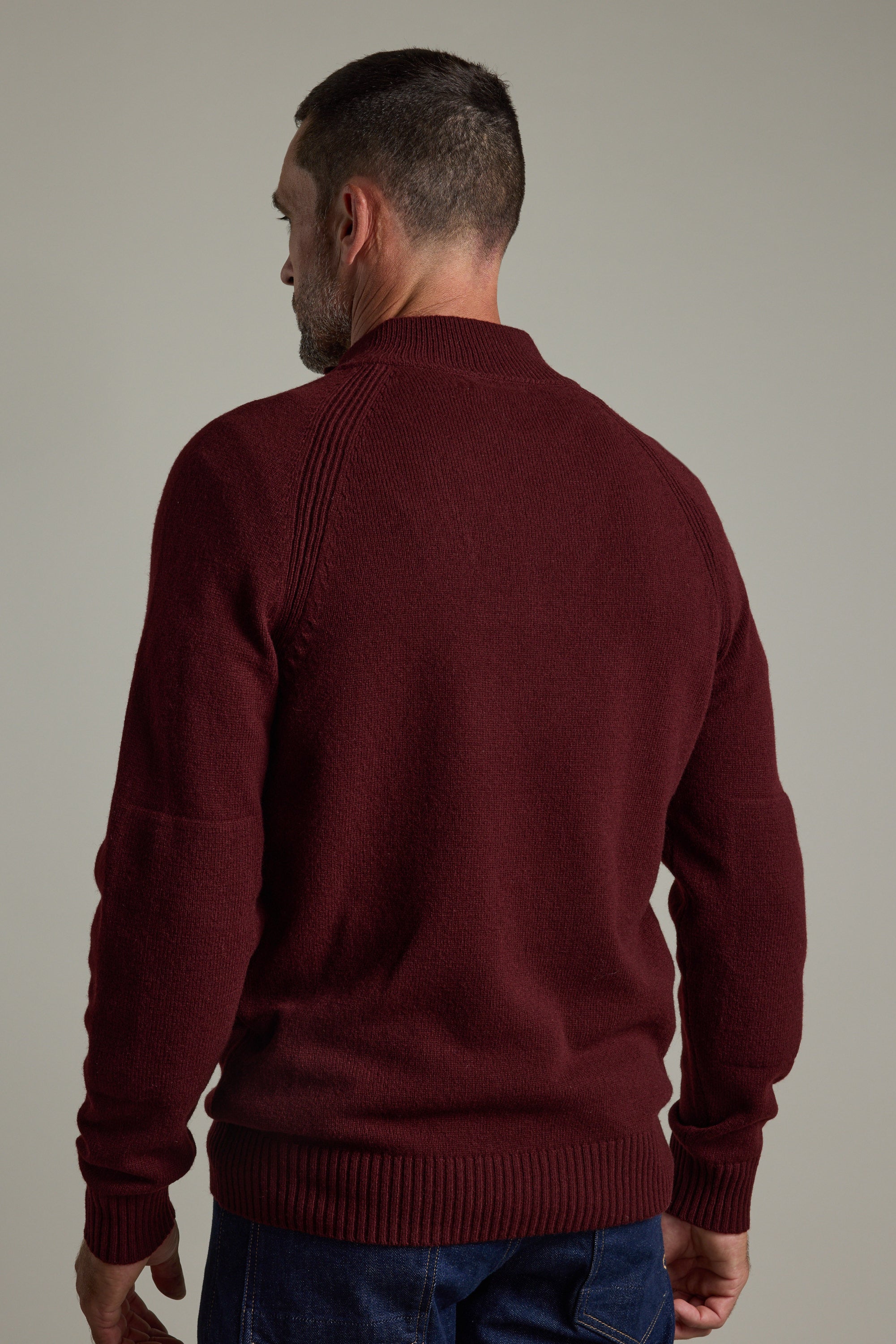 Man in a Barkers Rowley Woollen 1/4 Zip and jeans standing with his back to the camera.