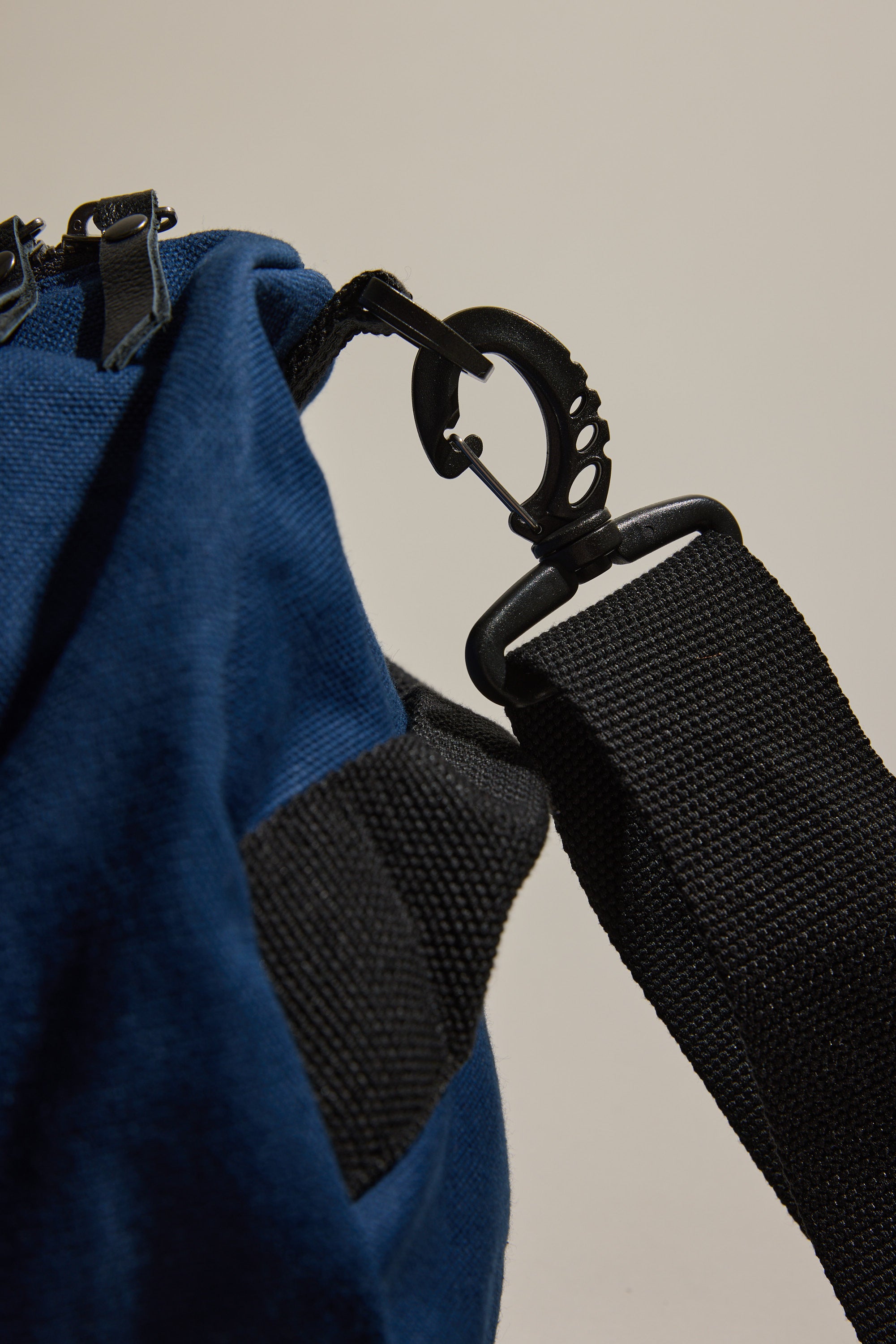 Close-up of the Barkers Canvas Duffle Bag in blue cotton canvas with a black adjustable strap and plastic swivel hook. Set against a plain background, this Barkers bag is the perfect companion for any journey.