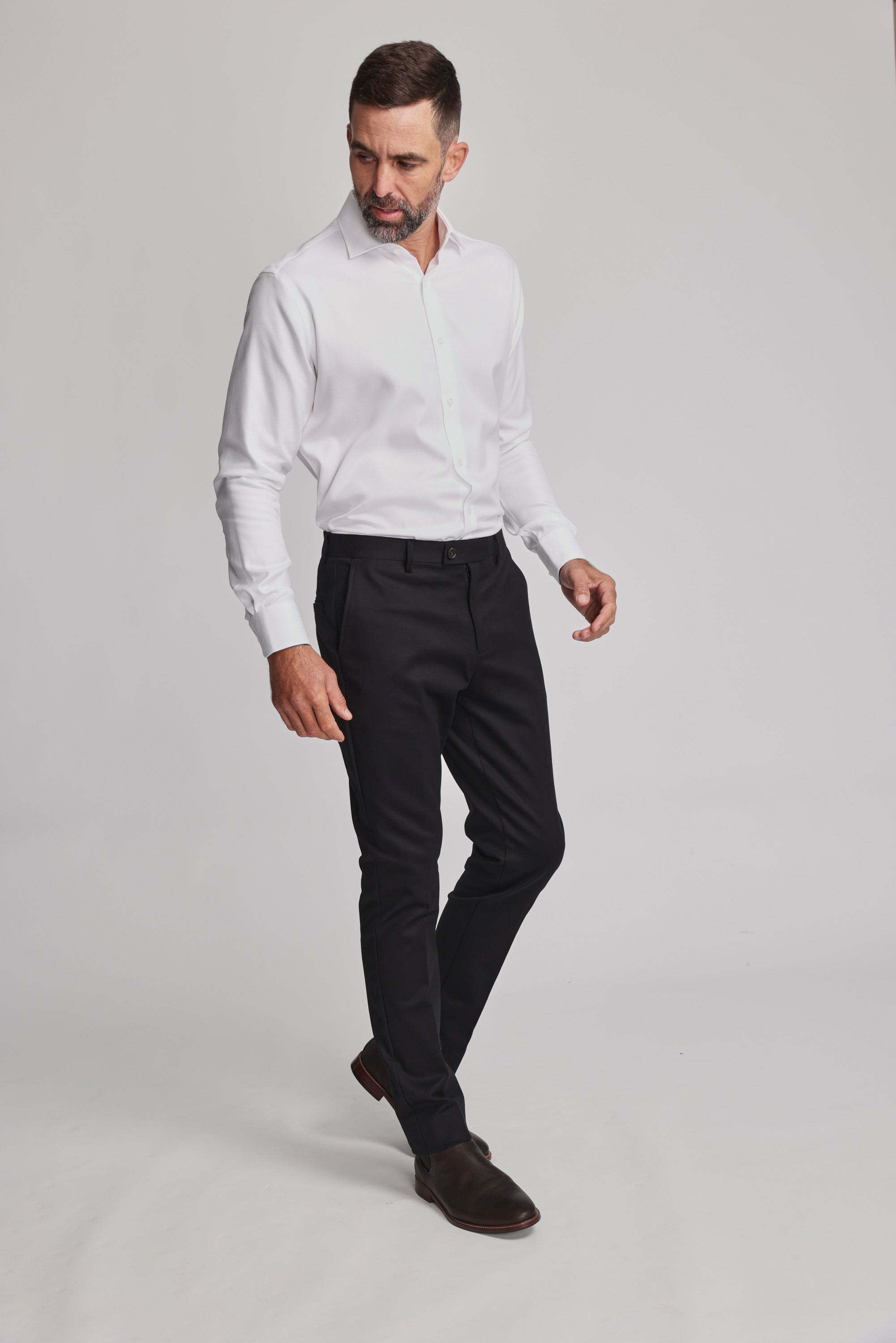 A man with short dark hair and a beard wears the Barkers Mexted Texture Shirt, black dress pants, and brown shoes. He stands against a plain light background, looking down to his left.